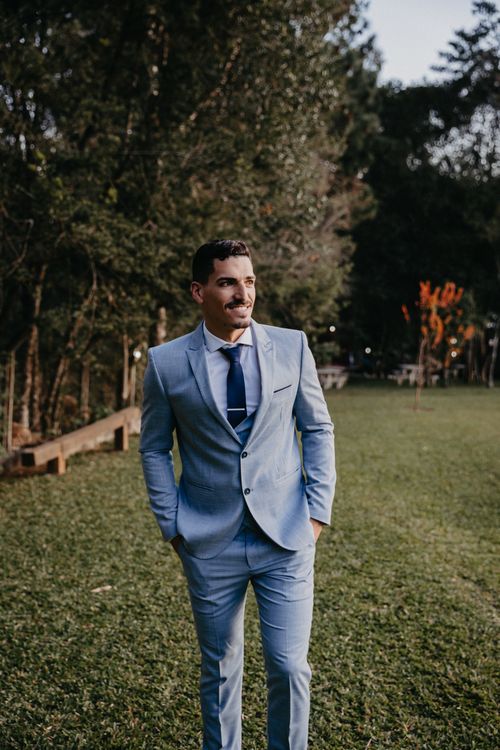 Free A man in a blue suit smiling outdoors in a natural setting. Stock Photo