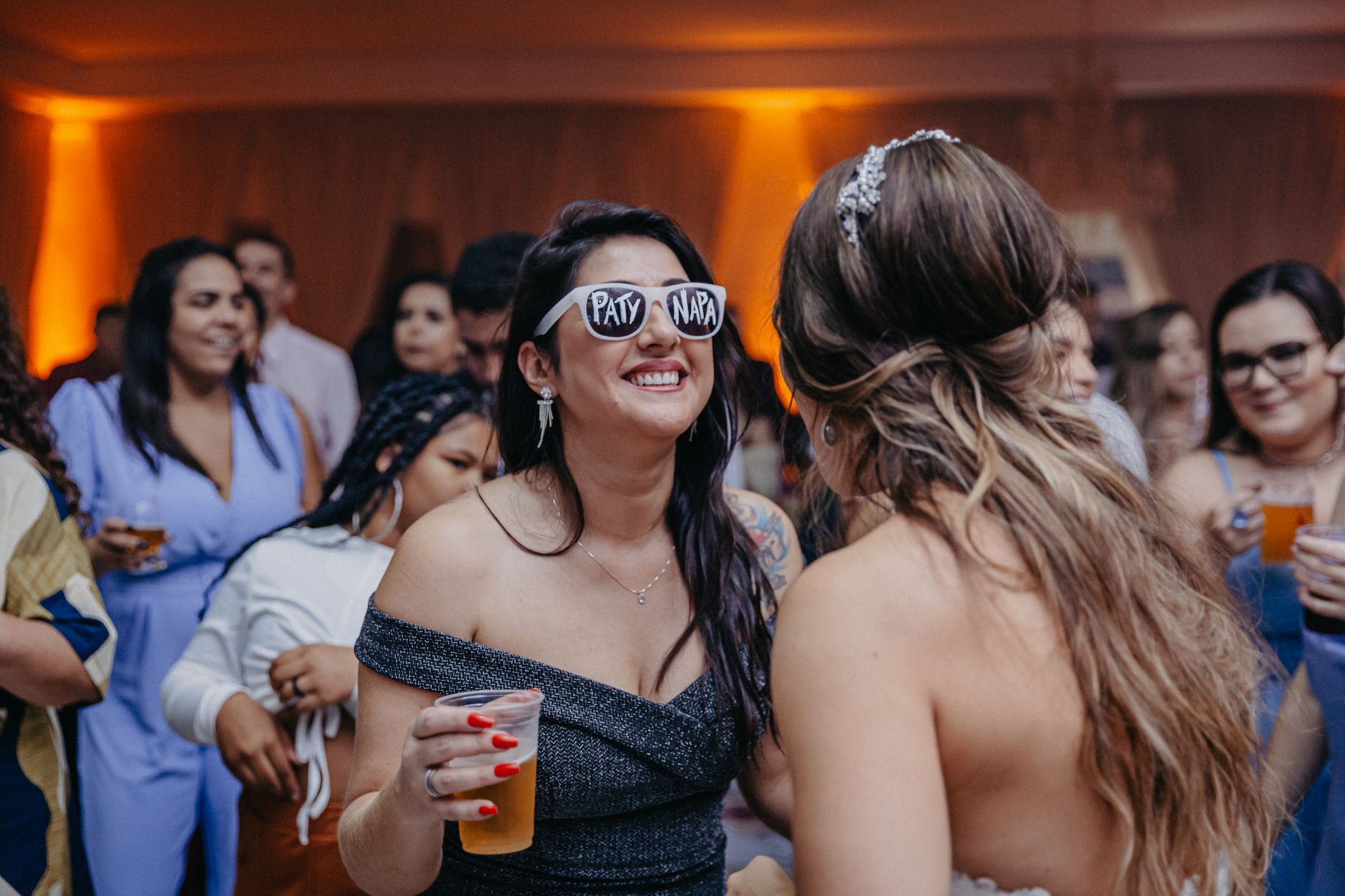 A lively wedding reception with guests enjoying drinks and dancing.