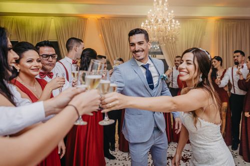 Free A joyful bride and groom toast with guests in a lively wedding celebration indoors. Stock Photo