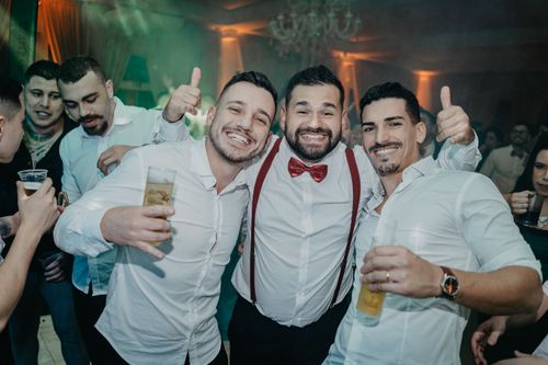 Free A group of happy adult men enjoying drinks and cheering at an indoor party. Stock Photo