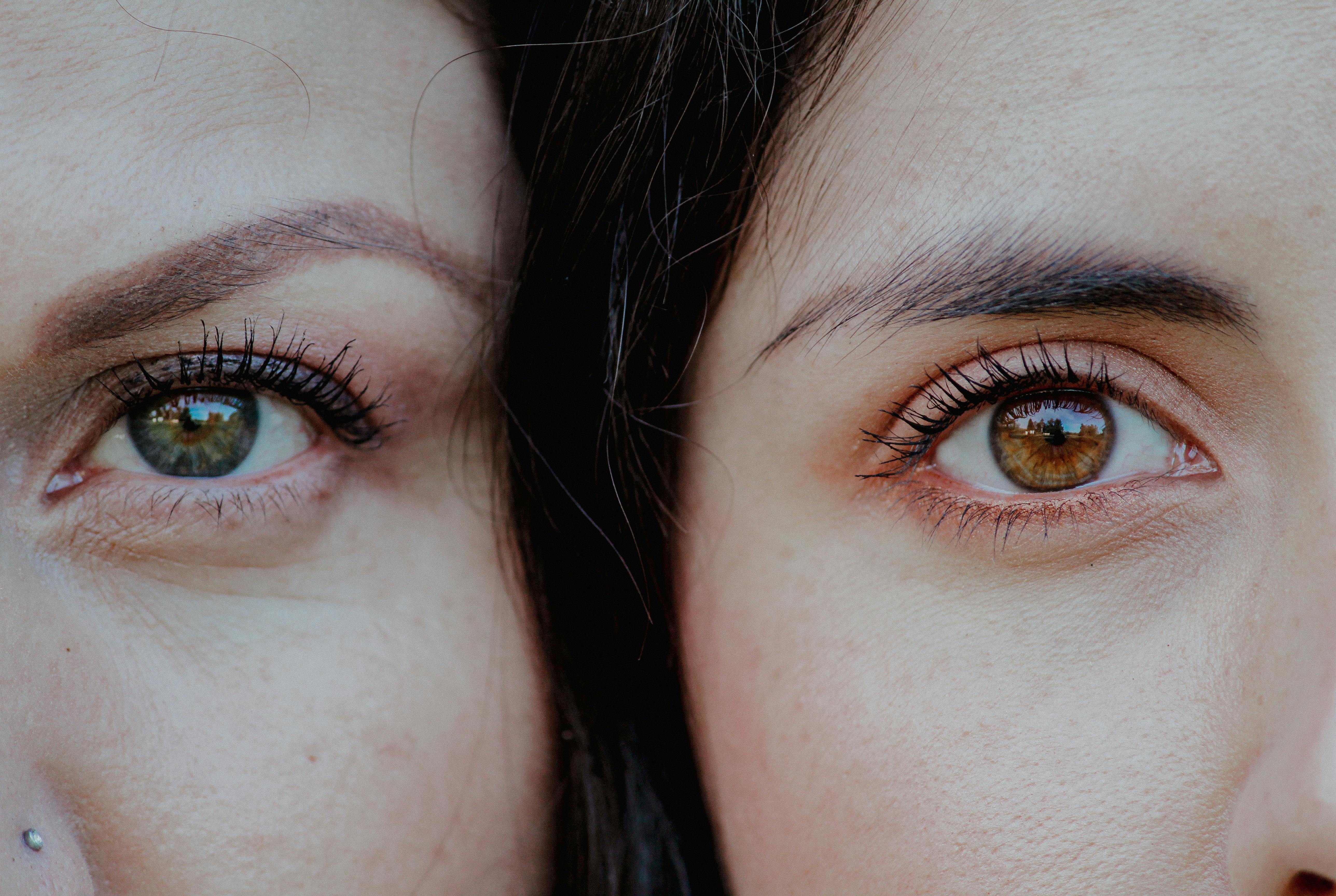 A detailed close-up of two female eyes with distinct iris colors, showcasing natural beauty.