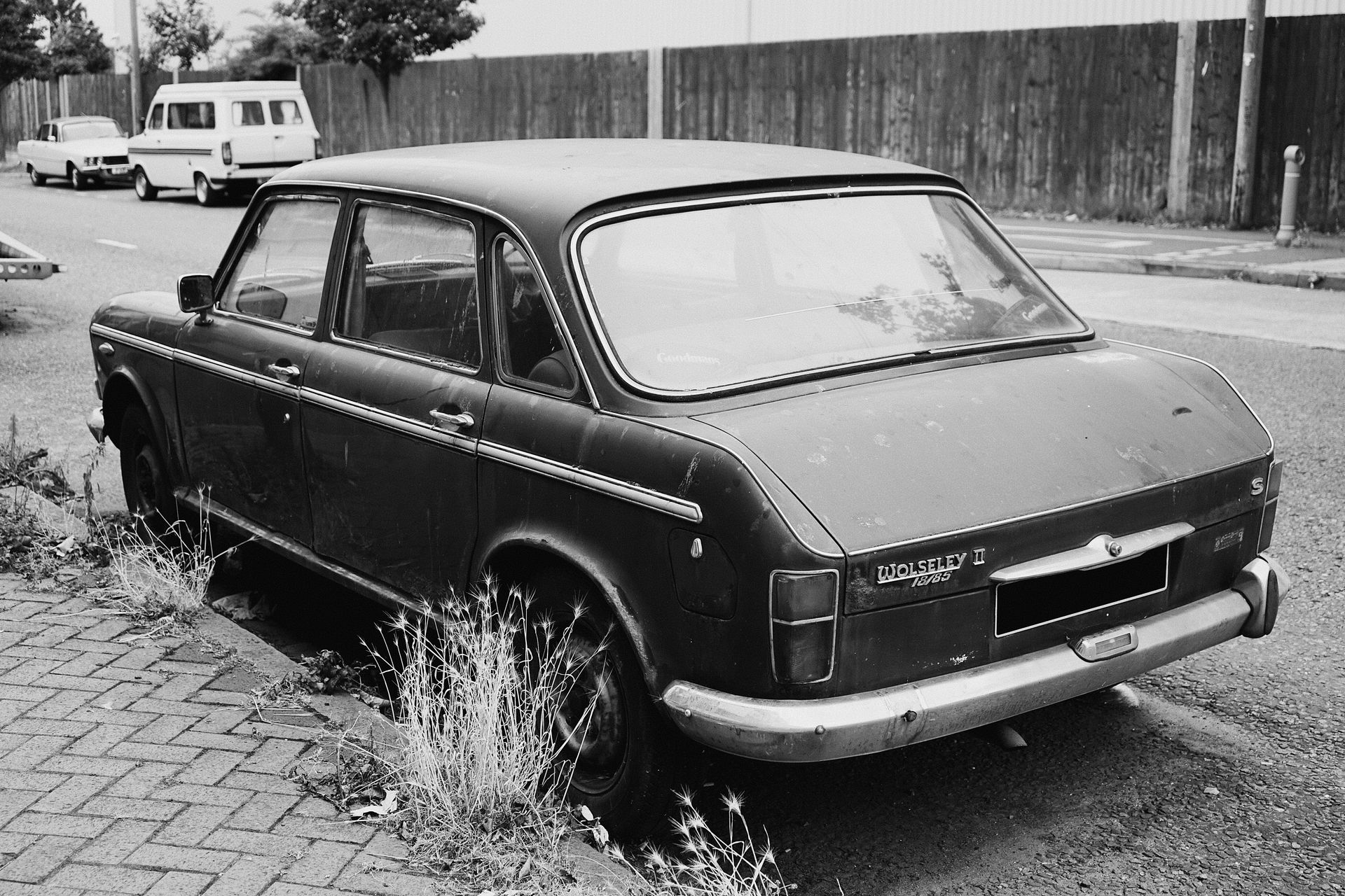 Monochrome photo of a vintage Wolseley car parked on a street in Liverpool, UK.