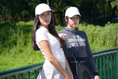 Free Two young women posing with tennis rackets outdoors in Mexico City, showcasing a casual sporty style. Stock Photo