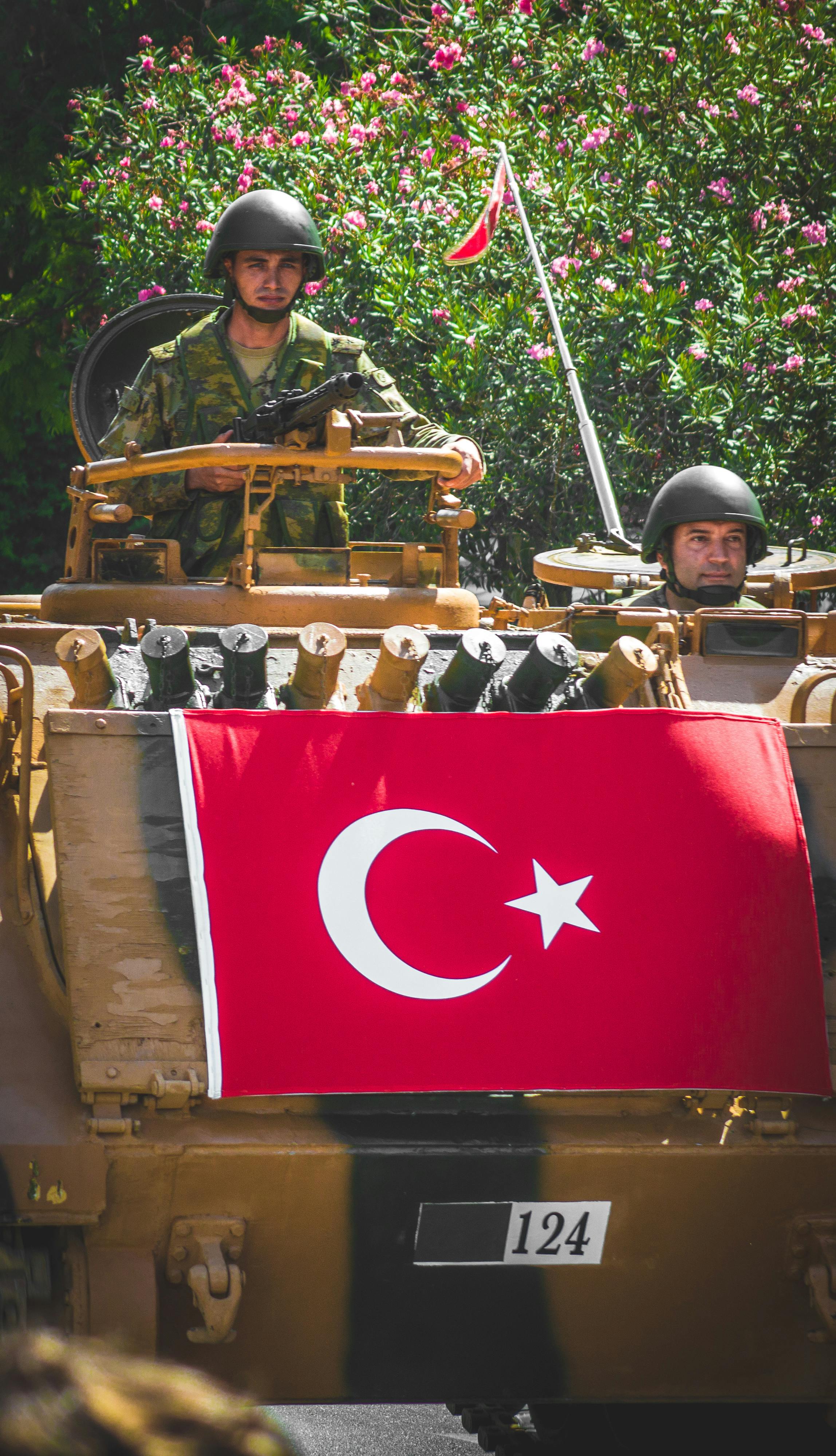 Turkish soldiers in an armored vehicle showcasing national pride with the Turkish flag displayed prominently.