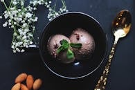 碗里放着美味的巧克力冰淇淋，上面装饰着薄荷叶和杏仁