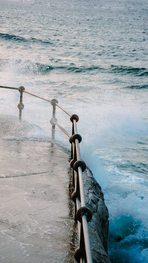 Waves by the Fence on a Pier 
