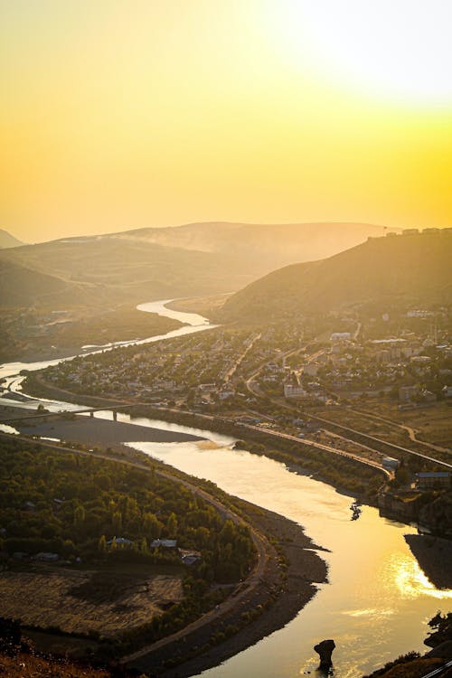 Aerial Photography of River near Mountains during Sunset