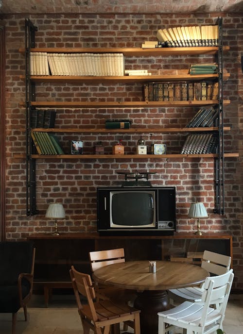 Books on a Bookshelf Hanging on a Brick Wall