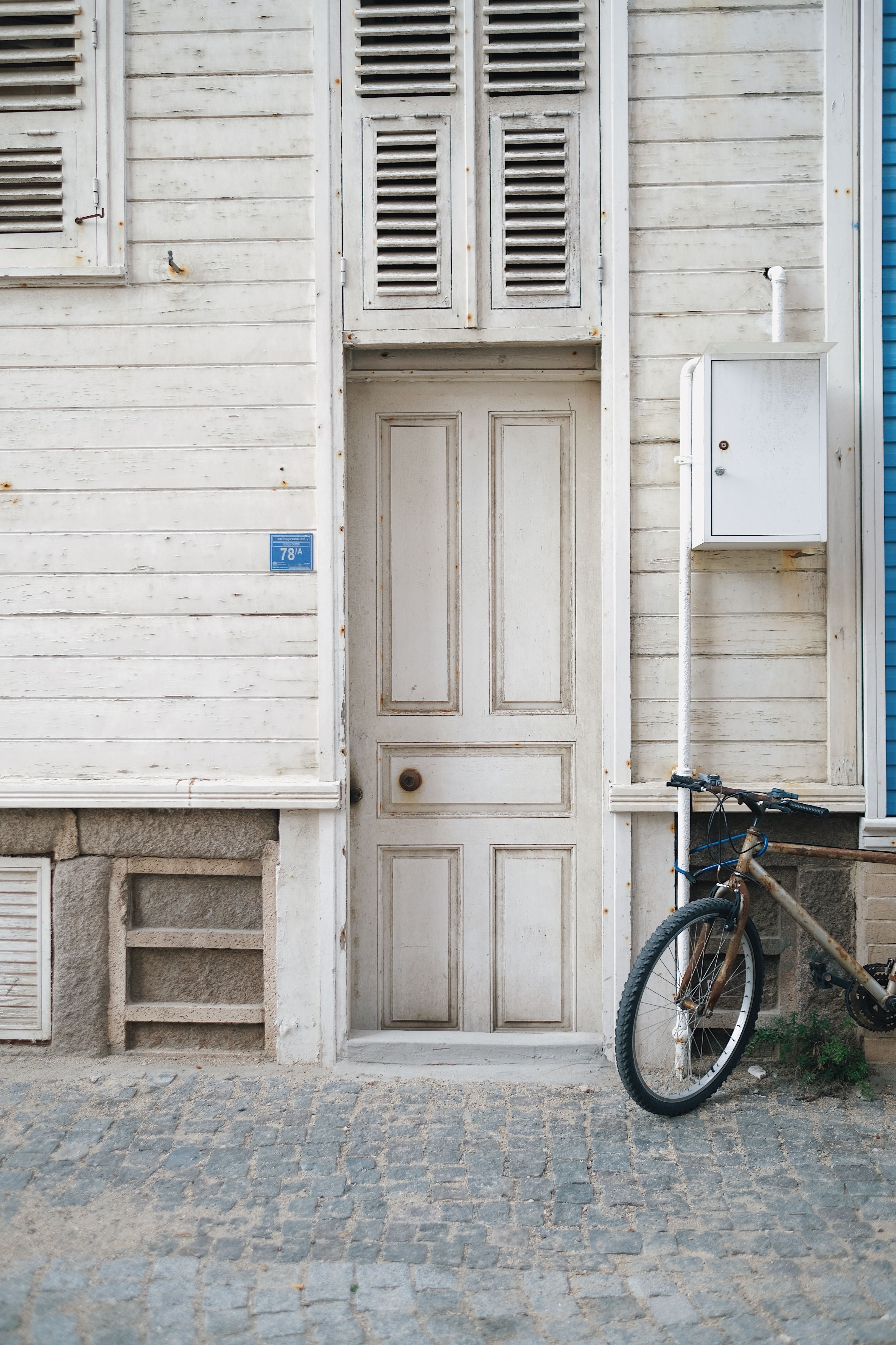 A rustic urban doorway with weathered wood facade and bicycle.