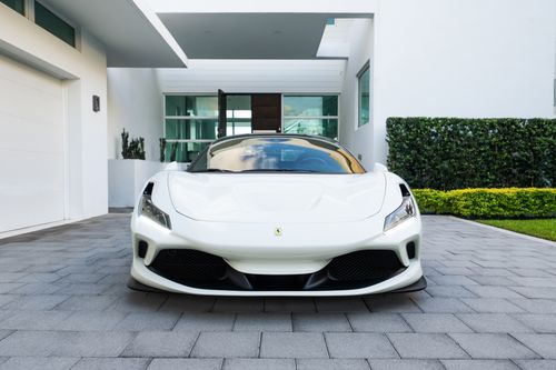 Free Elegant white sports car parked in front of a modern home on a stone driveway. Stock Photo
