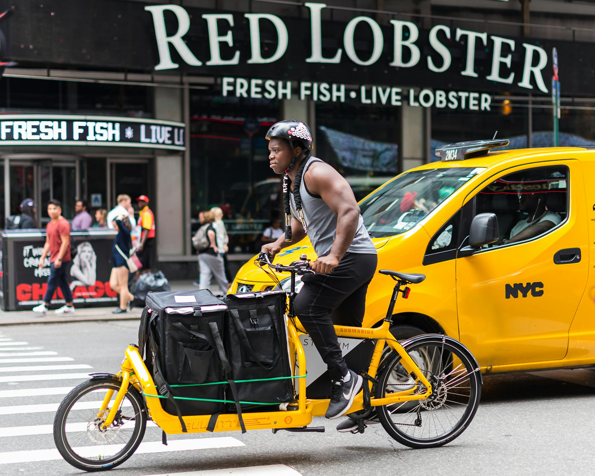 Man Driving a Yellow Cargo Bike in the City Street