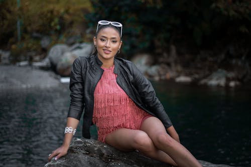 Young Woman Sitting on a Rock by the River 