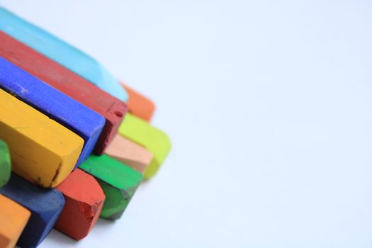 Close-up of colorful dry pastels arranged on a white background with copy space.