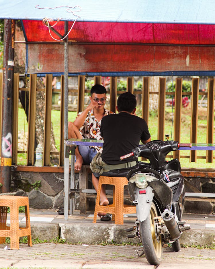 Men Sitting By The Table Talking