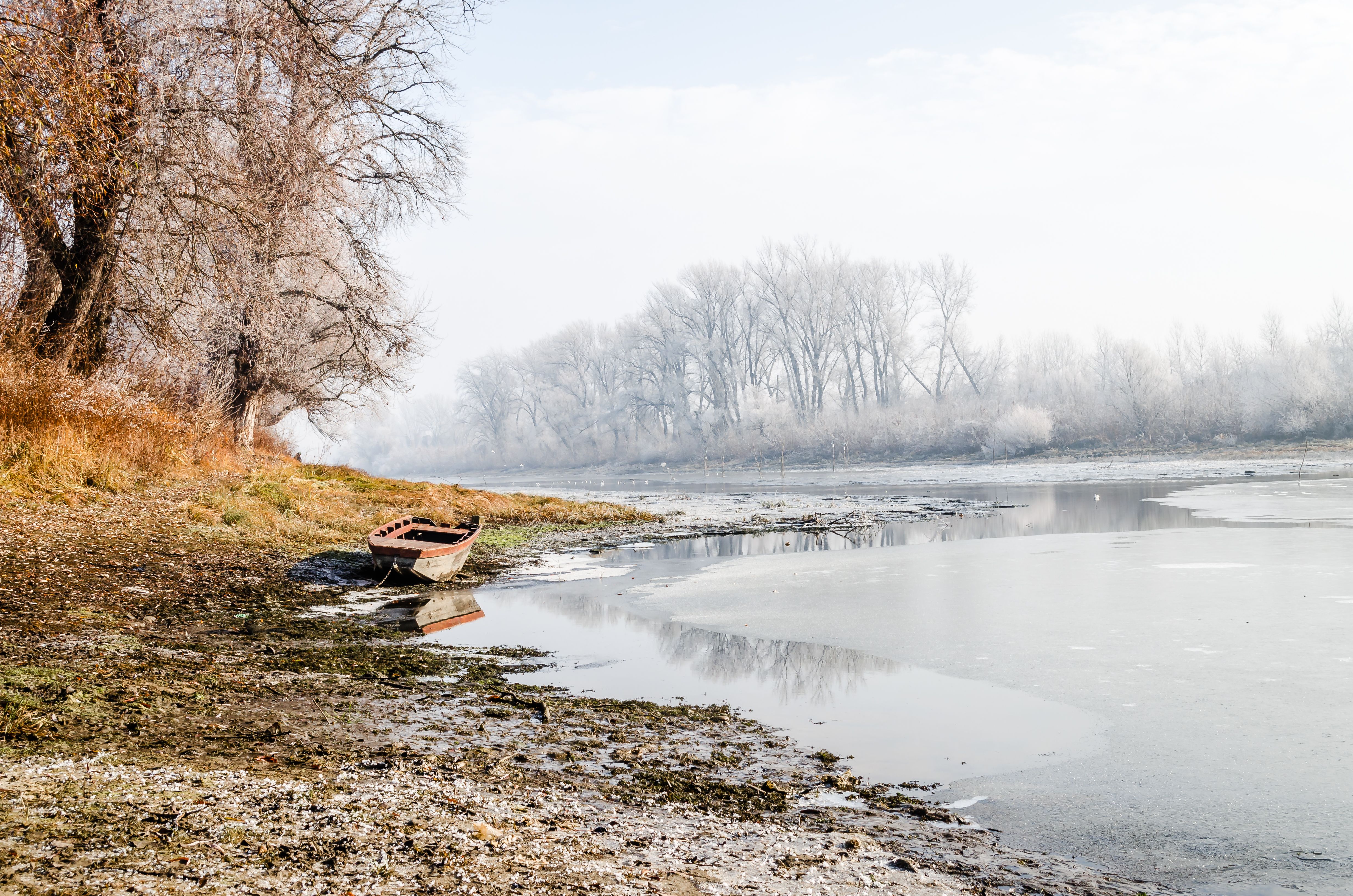 Serene winter landscape featuring a boat on a frozen lake in Novi Sad, Serbia.