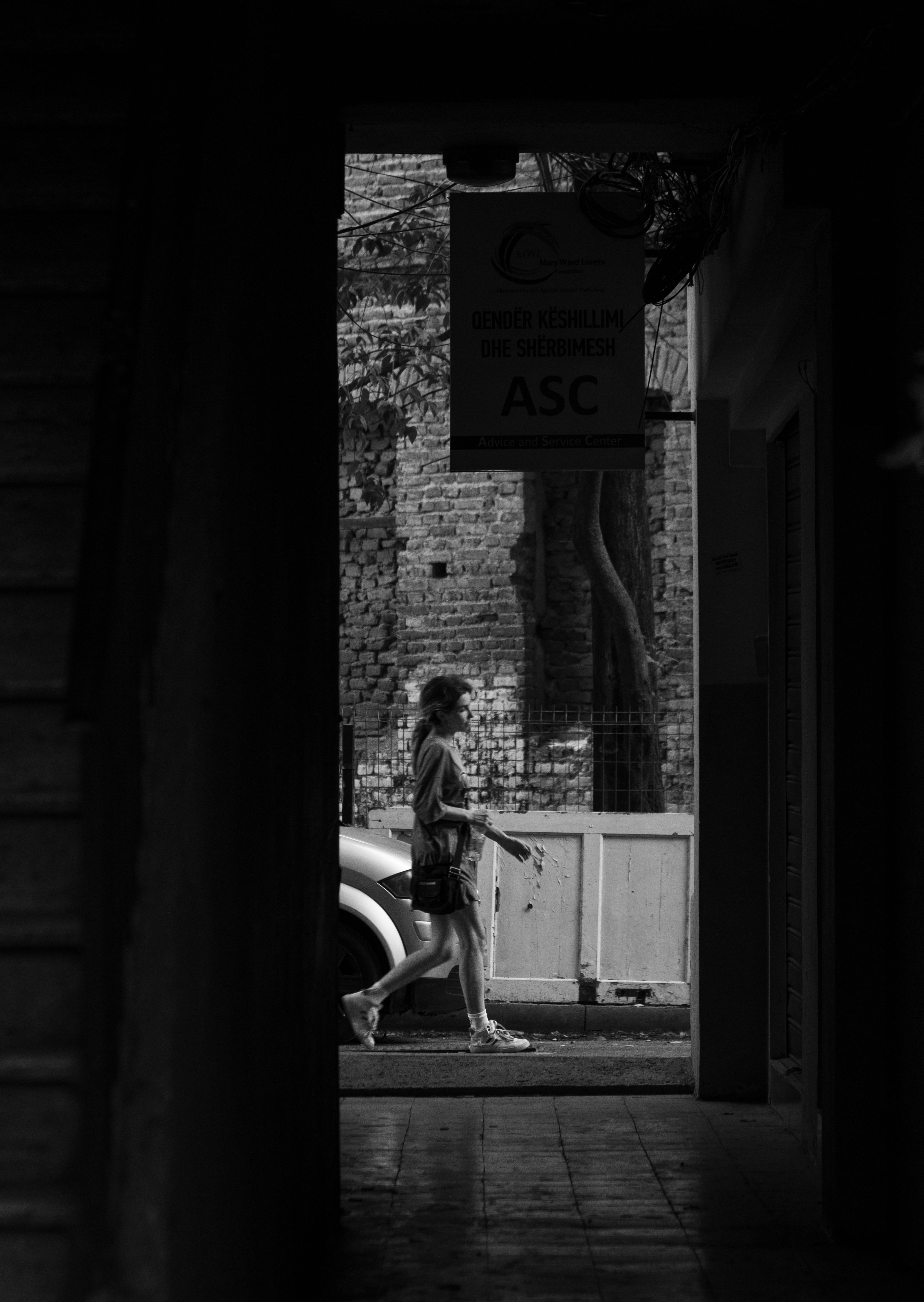 A Grayscale of a Woman Walking on a Street · Free Stock Photo