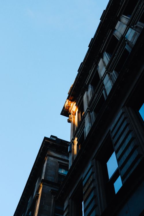 Free Low angle view of a building facade with sunlight at sunrise. Stock Photo