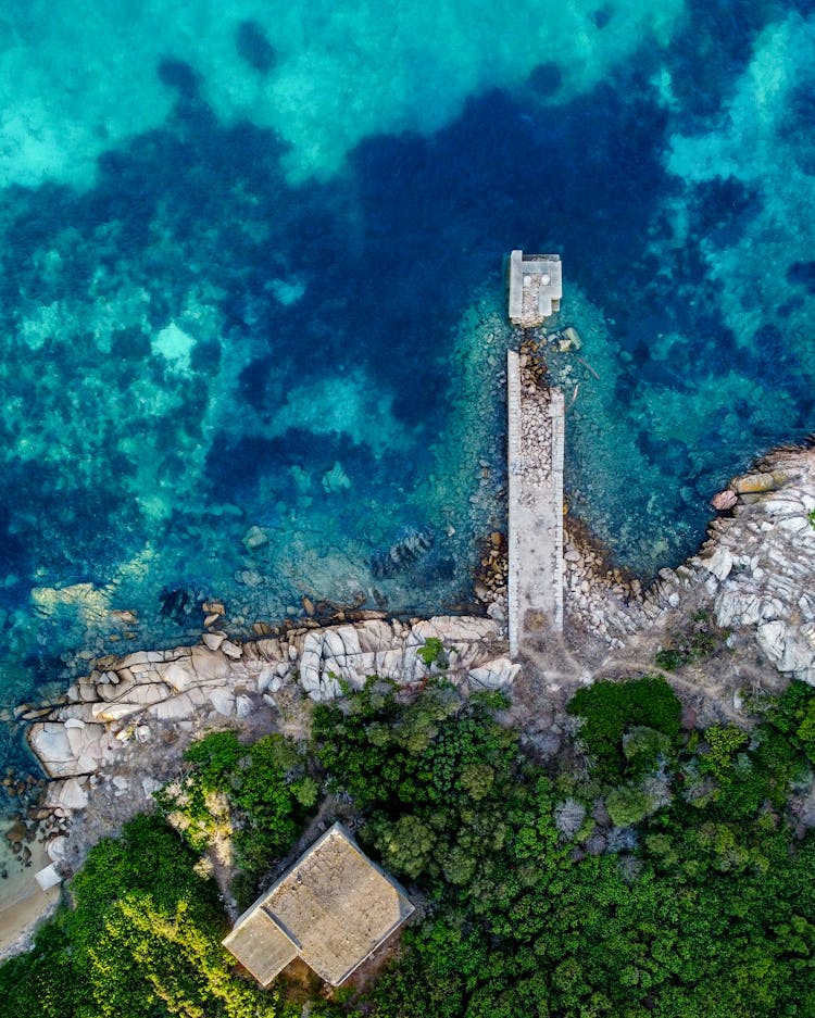 Aerial View Of House Standing By Sea On Rocky Coast