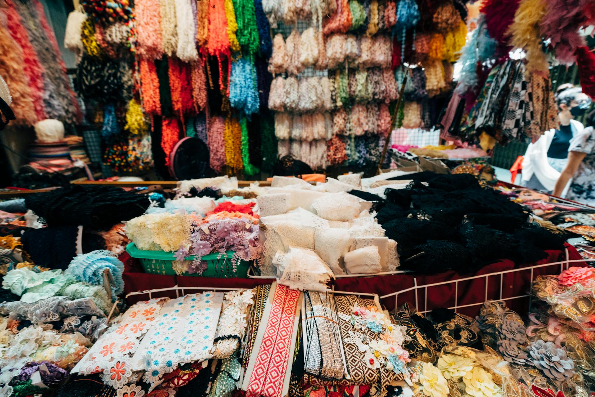 A bustling market stall showcasing a variety of vibrant fabrics and textiles, perfect for fashion and design.