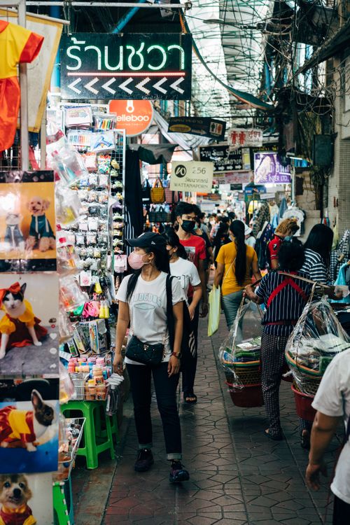 Free Vibrant street market in Thailand with diverse shoppers exploring stalls. Captures lively atmosphere. Stock Photo