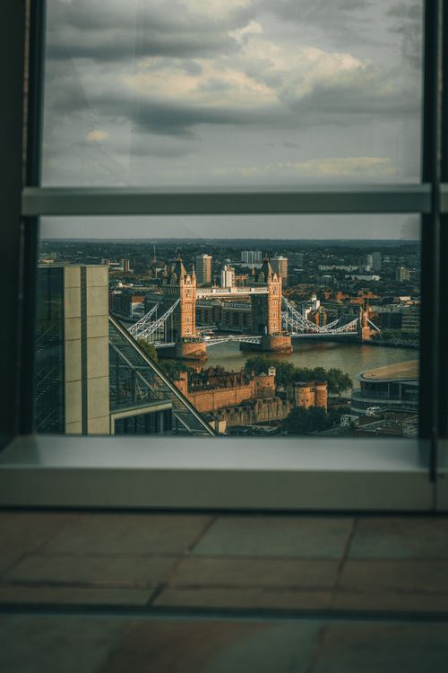 Free Captivating view of Tower Bridge in London framed by a window, showcasing the city's skyline. Stock Photo