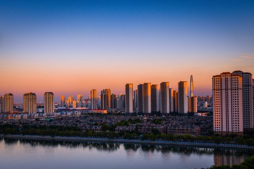 Free A stunning urban skyline showcasing skyscrapers by the river during sunset. Stock Photo