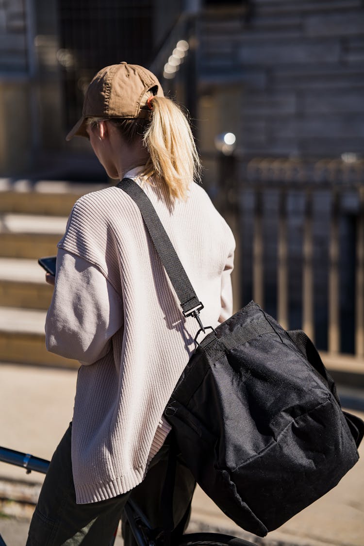 Blonde Woman With Big Shoulder Bag Looking To Mobile Phone