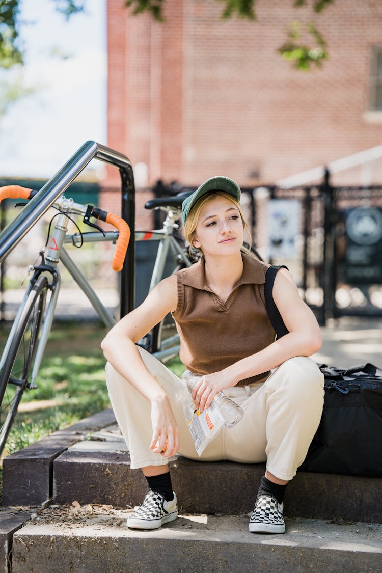 Delivery Girl Sitting On Street Stairs And Resting