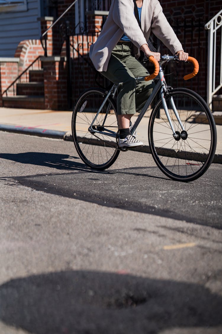 Unrecognizable Woman Riding Bike In Street