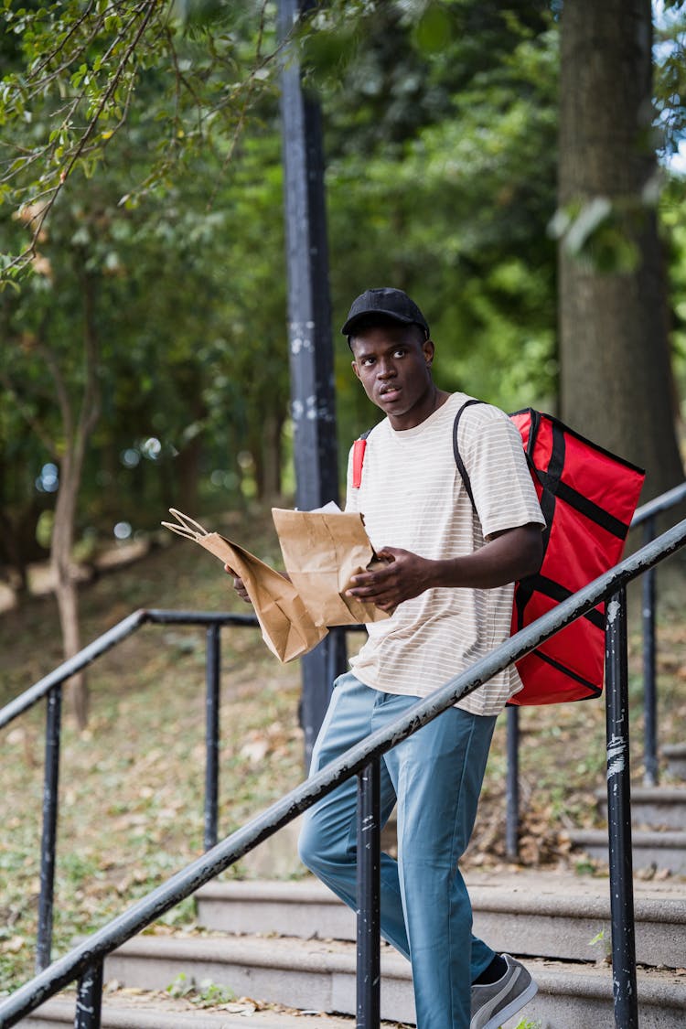 Delivery Man Carrying Paper Bags With Ordered Meals