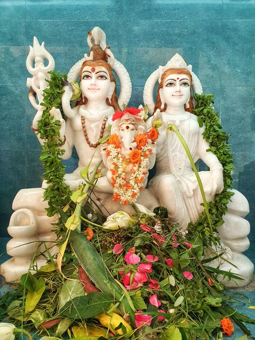 Free Statues of Hindu deities adorned with flowers and garlands symbolizing tradition and spirituality. Stock Photo