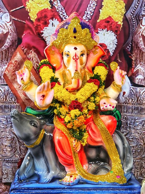 Free Vibrant Ganesha statue adorned with floral garlands, symbolizing Hindu culture and tradition. Stock Photo