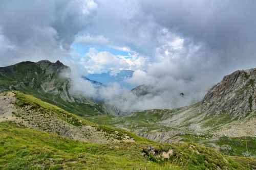 Free Dramatic clouds envelop a rocky mountain landscape, showcasing nature's raw beauty. Stock Photo