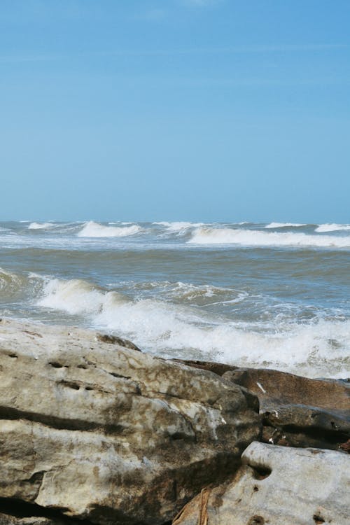 Ocean Waves Crashing on Brown Rocky Shore