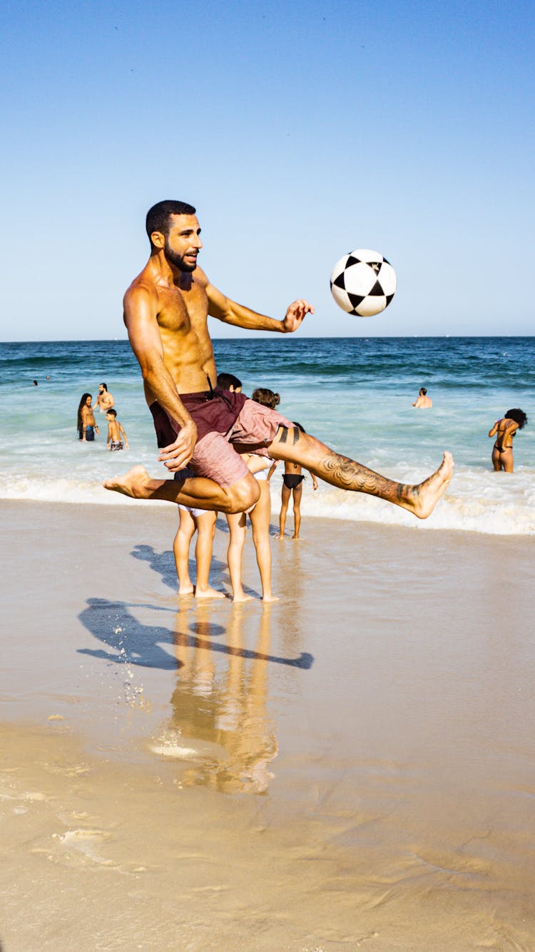 Man Playing Soccer At The Beach