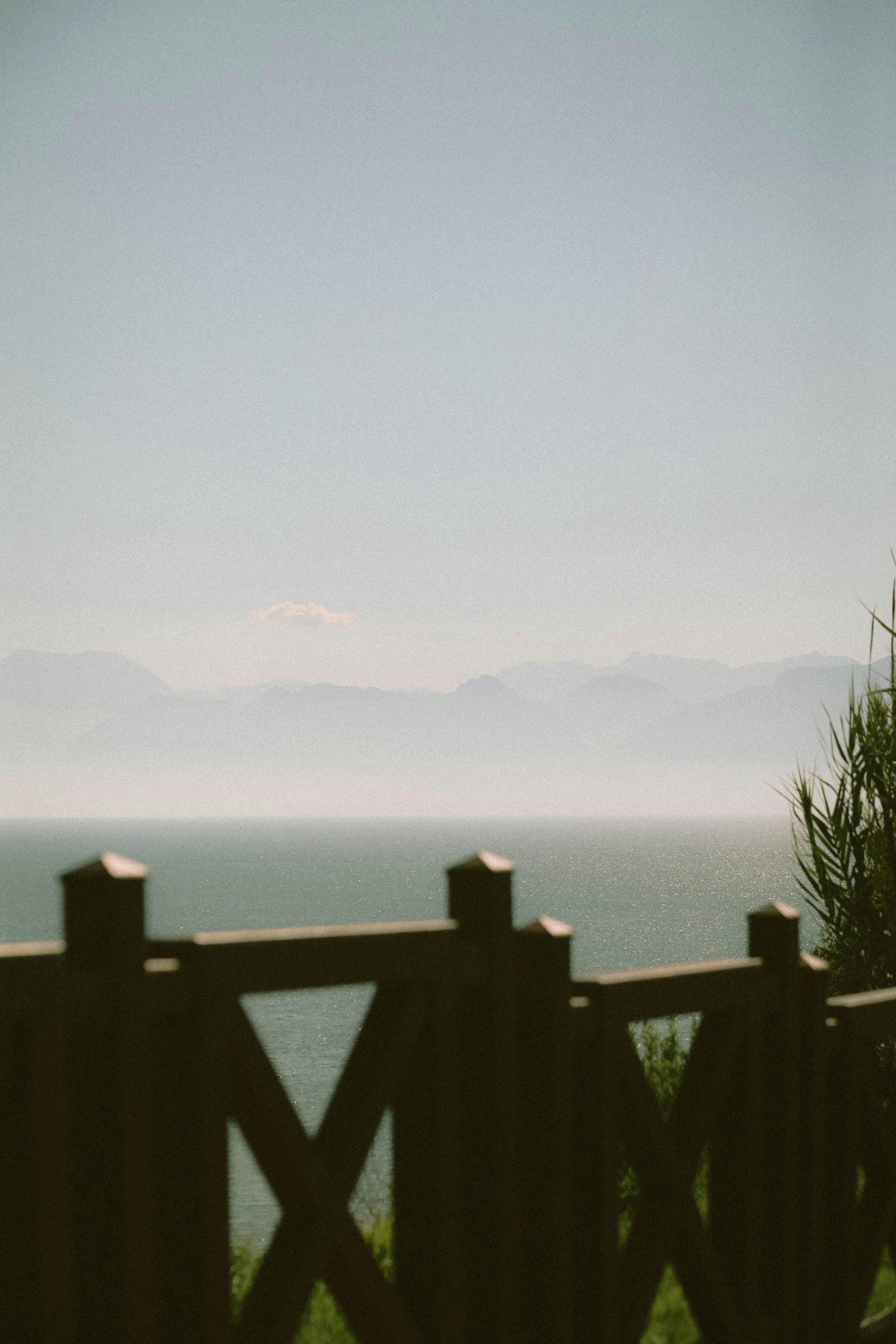 Tranquil view of the Mediterranean Sea from Antalya, Turkey, framed by a wooden fence.