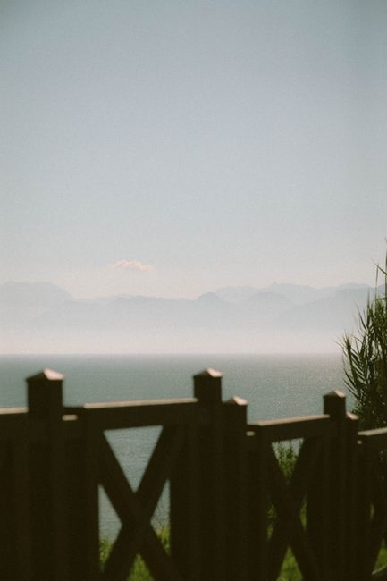 Tranquil view of the Mediterranean Sea from Antalya, Turkey, framed by a wooden fence.
