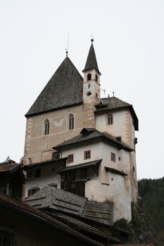 Discover the historic Sanctuary of San Romedio in Trentino-Alto Adige, showcasing unique architecture against a cloudy sky.