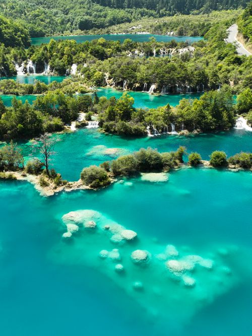 Free Stunning aerial shot of vibrant turquoise lakes and lush forests at Plitvice Lakes National Park. Stock Photo