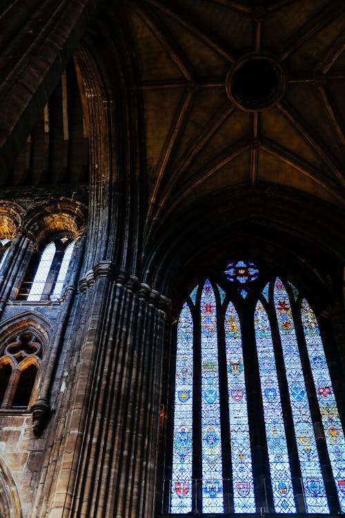 Low Angle Shot of a Gothic Church Stained Glass Windows and Ceiling