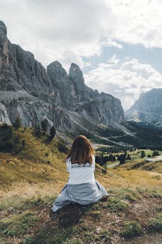 Woman sitting and enjoying the breathtaking view of the Dolomites in Italy.