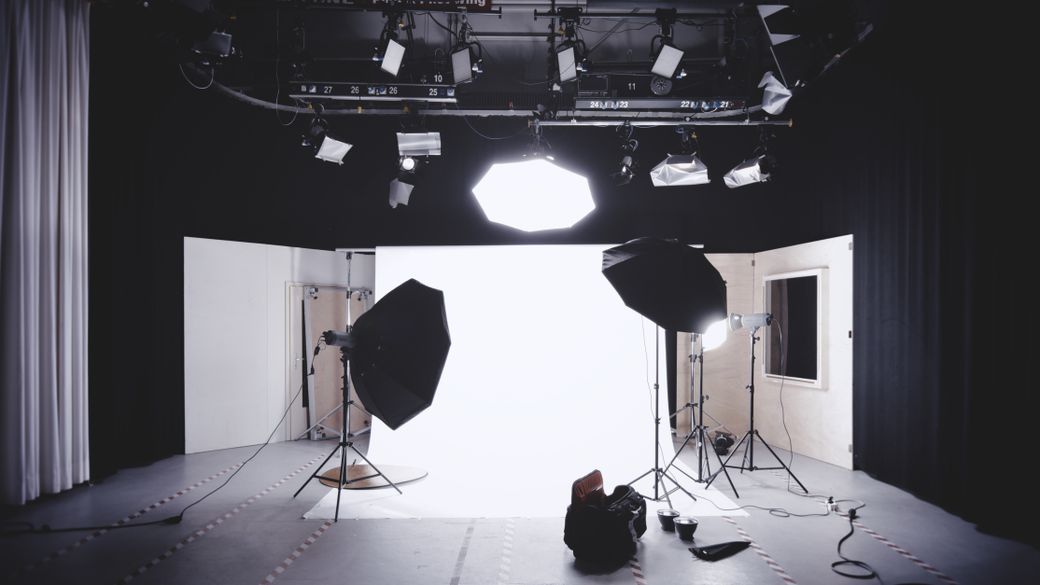 Empty studio stage lit by softboxes and overhead lighting rigs — photo by Alexander Dummer on Pexels