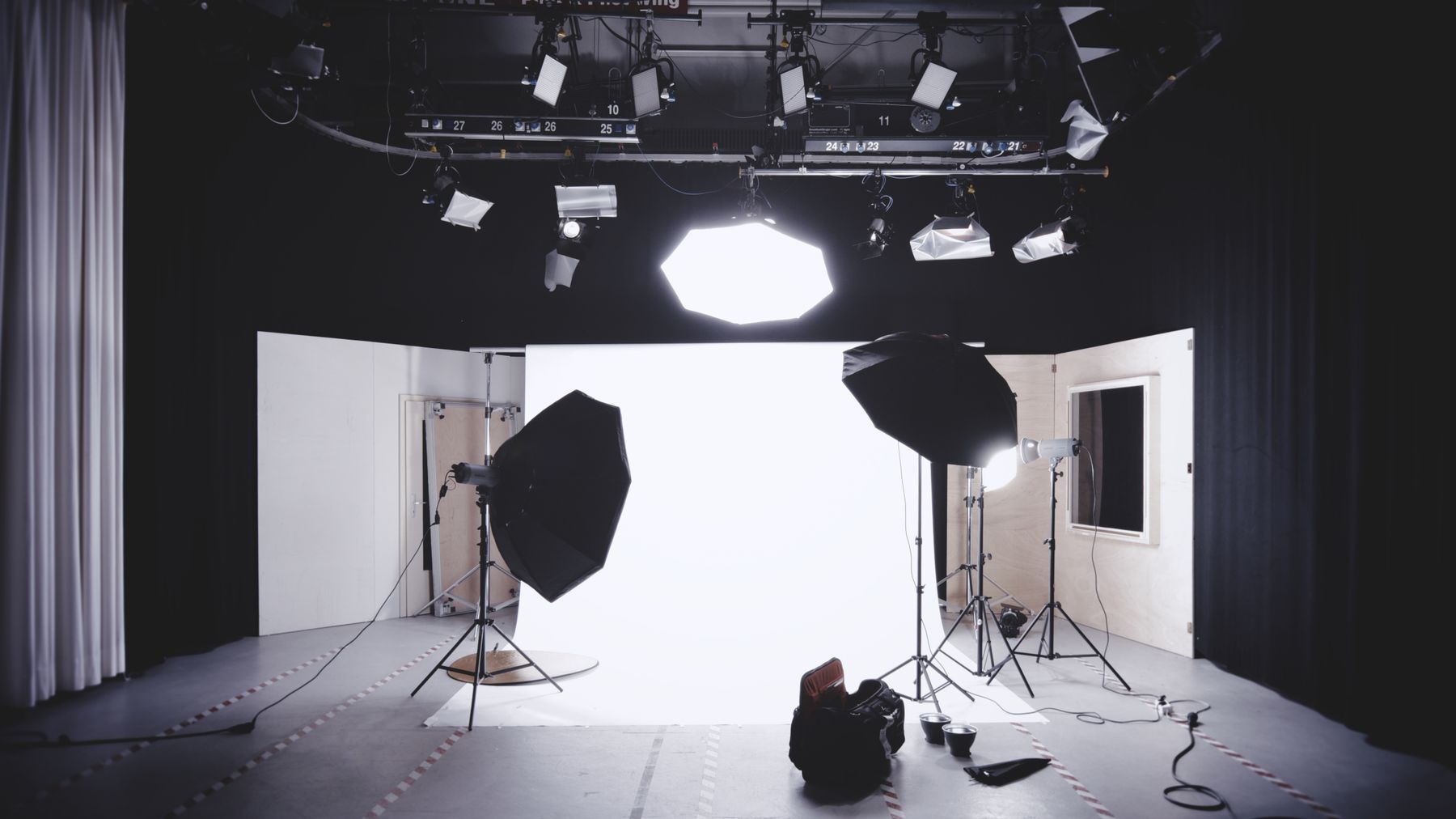 Studio photo professionnel équipé : fond blanc, softbox et éclairage cinématographique