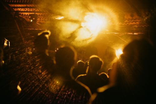 Free A lively crowd at a music concert with bright lights and smoke effects creating an energetic atmosphere. Stock Photo
