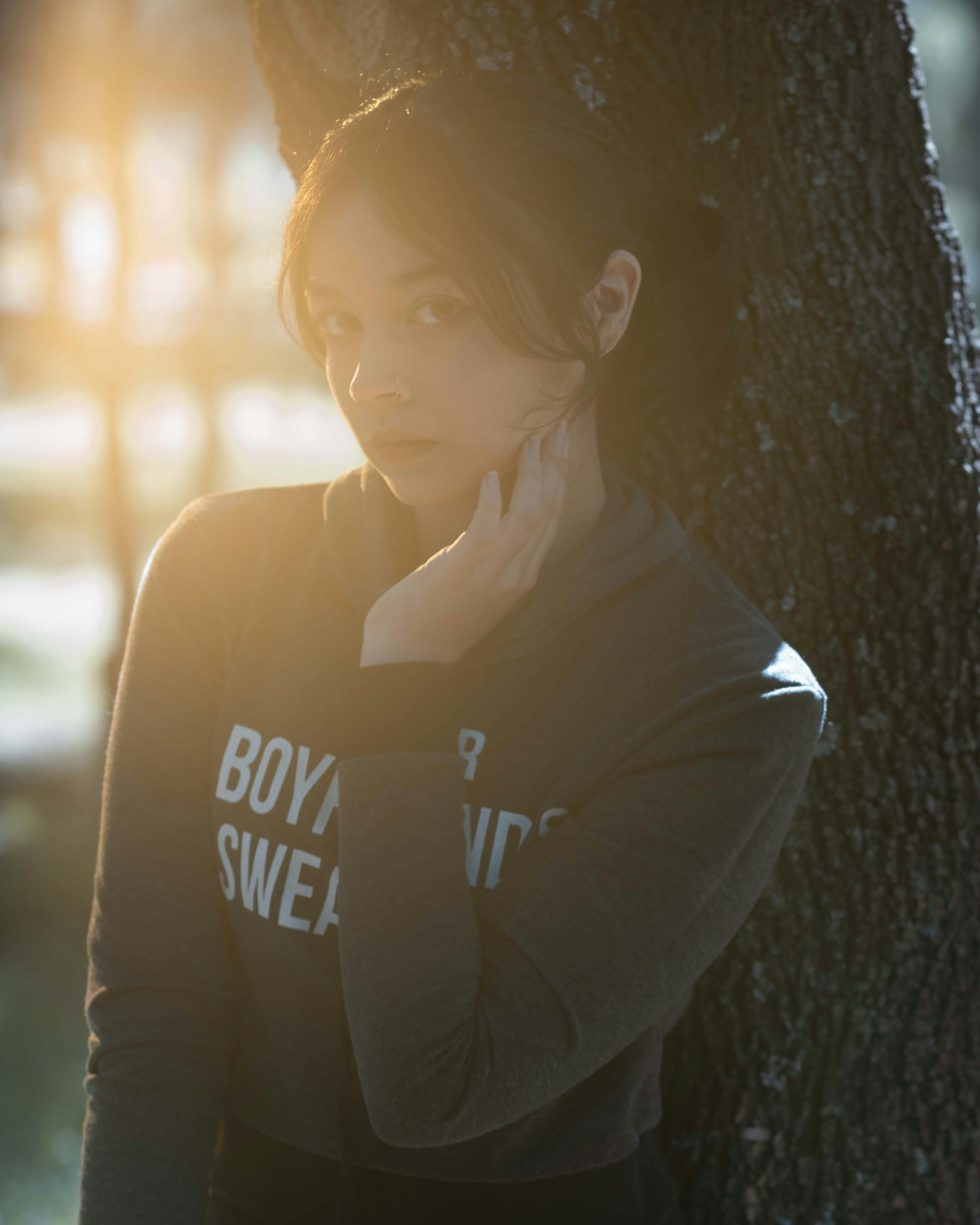 Girl in Gray Hoodie Leaning on Tree Trunk · Free Stock Photo