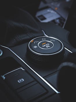 Detailed view of a car mode selector knob in a modern vehicle interior featuring technology and control elements.