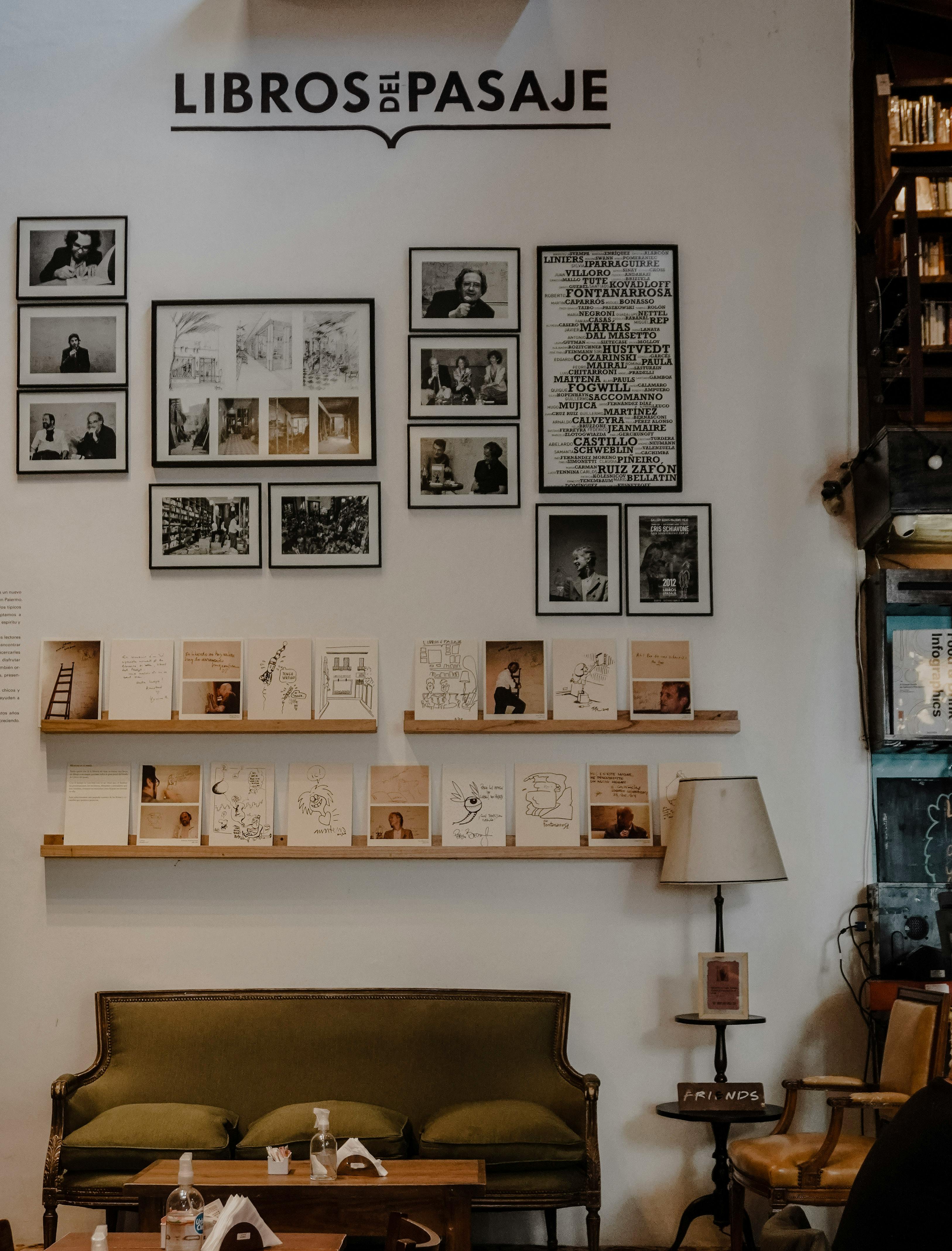 Warm ambiance of 'Libros del Pasaje' bookstore with framed art, books, and vintage decor in Buenos Aires.