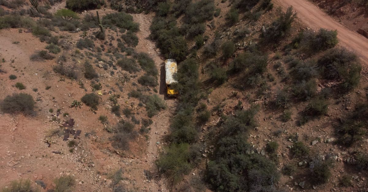 Aerial shot of an abandoned bus in the rugged desert terrain near Paxton Place, Arizona, USA.