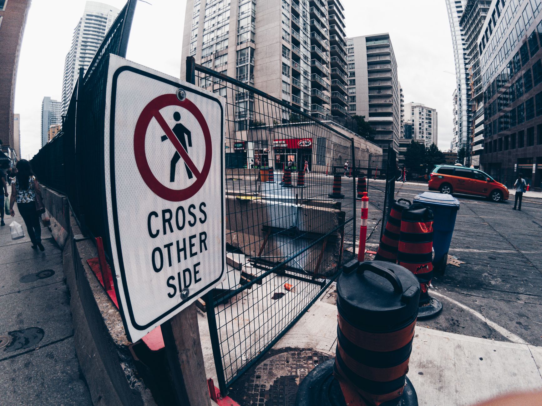 Street scene in Toronto showcasing construction barriers and warning signs.