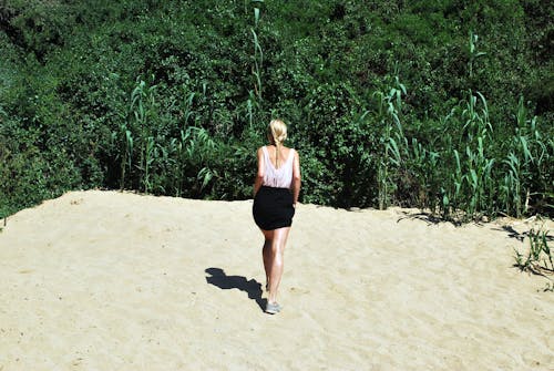 在沙滩上行走的女人